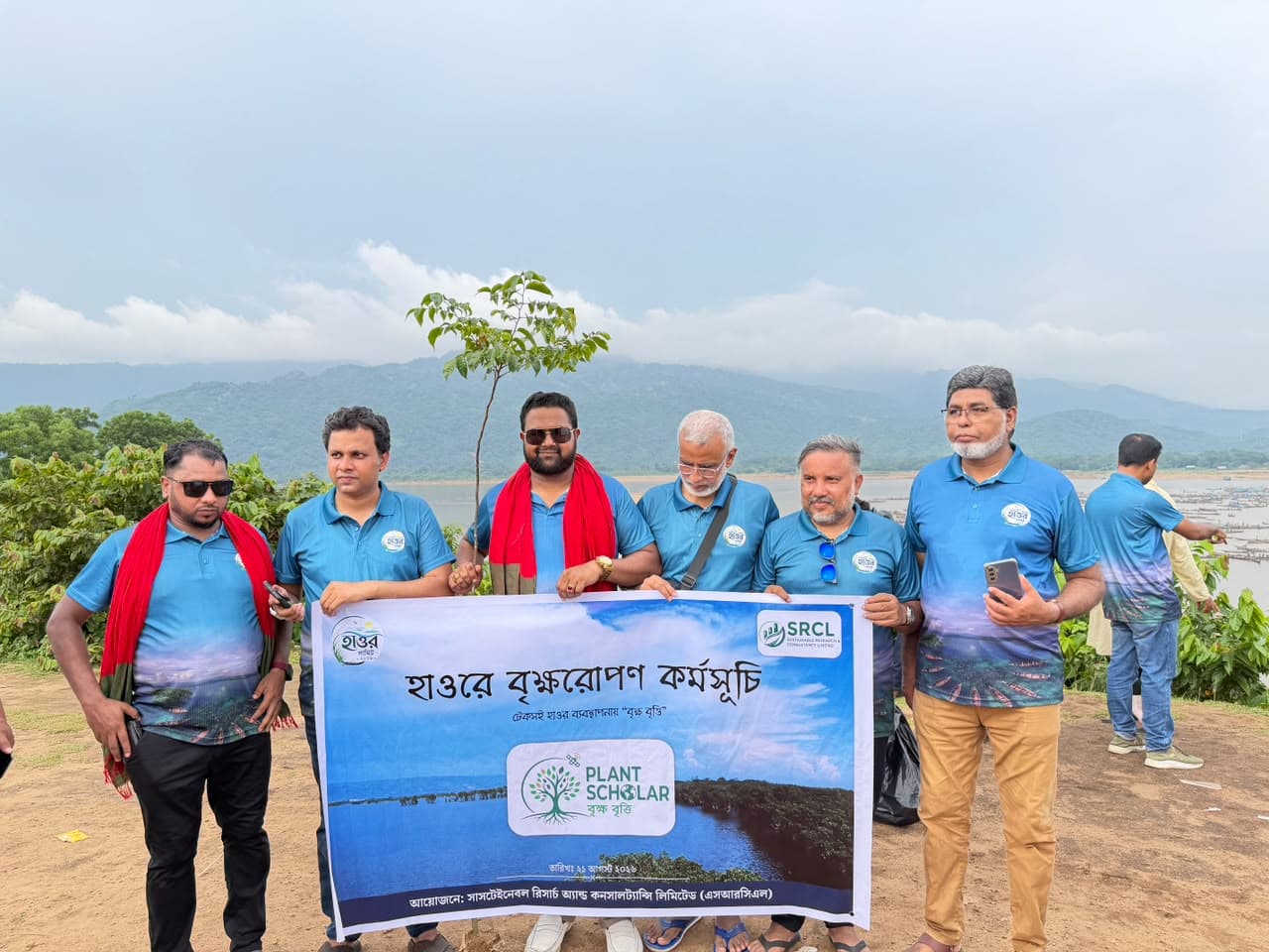 Md. Abu Jubayer and colleagues holding a PlantScholar tree-planting banner