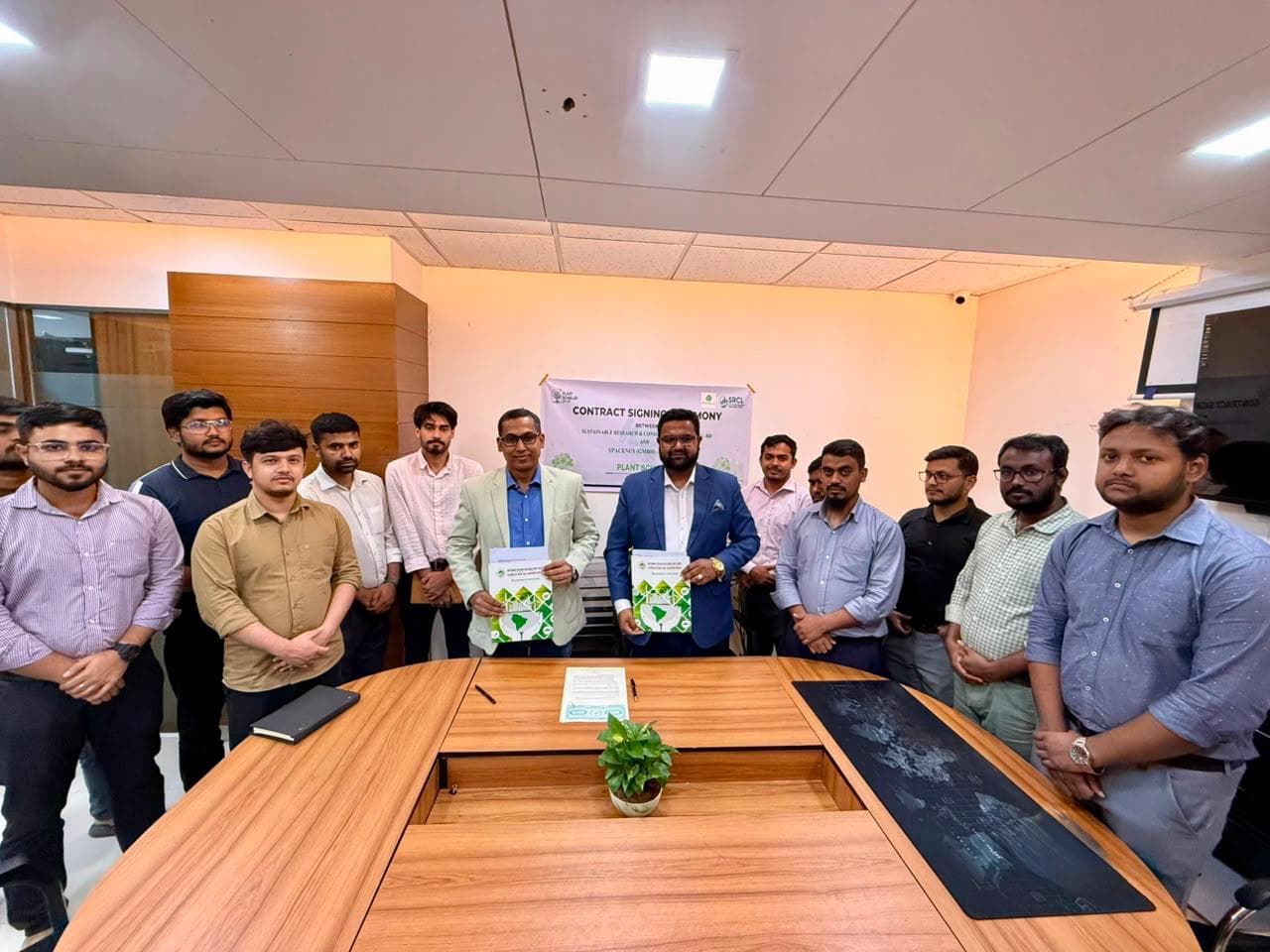 Md. Abu Jubayer and attendees holding documents at the PlantScholar signing ceremony